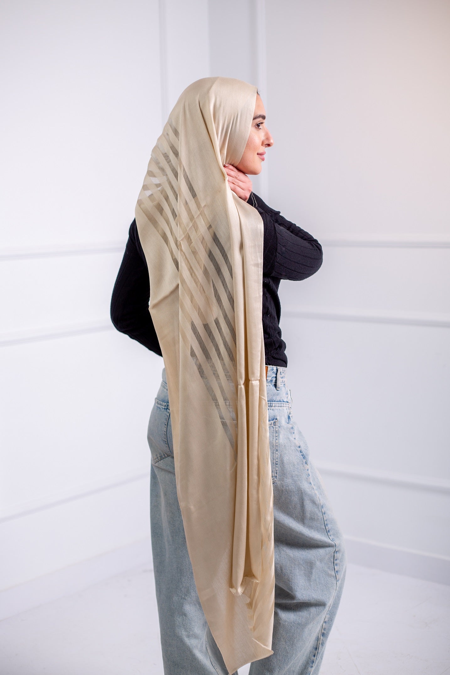 Silky Gold long hijab with line design, worn with casual jeans and a black top – back view2
