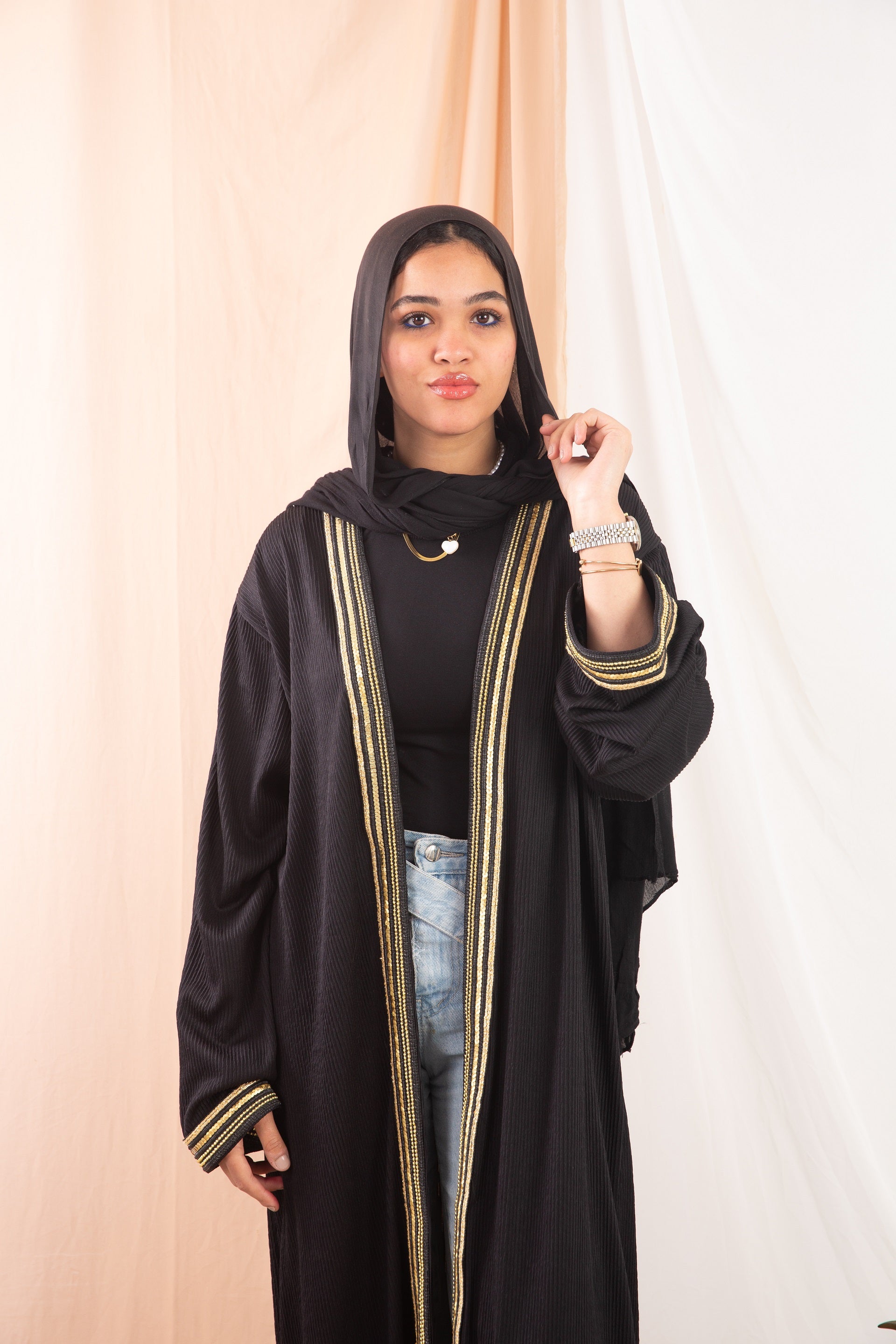 Nojom Kaftan  Black crafted from crinkle rib-knitted fabric, is adorned with delicate gold lines, adding a touch of elegance and sophistication.