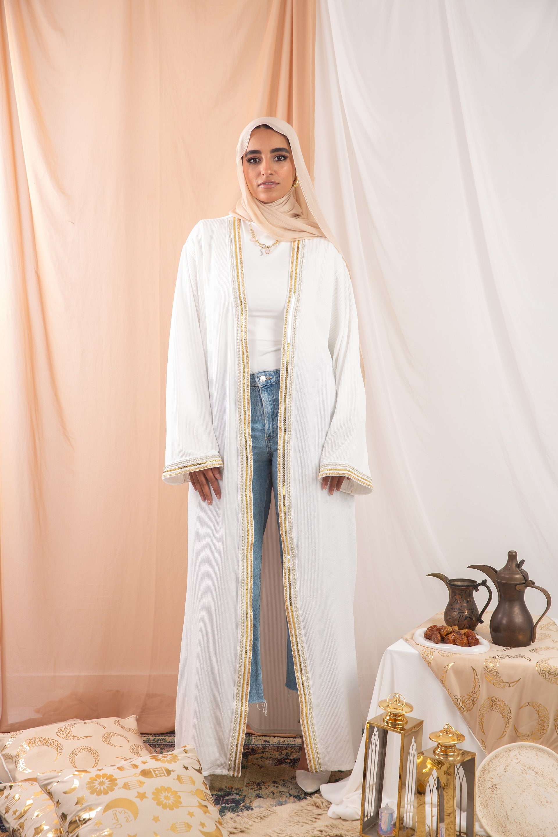 Nojom Kaftan  Off White crafted from crinkle rib-knitted fabric, is adorned with delicate gold lines, adding a touch of elegance and sophistication.