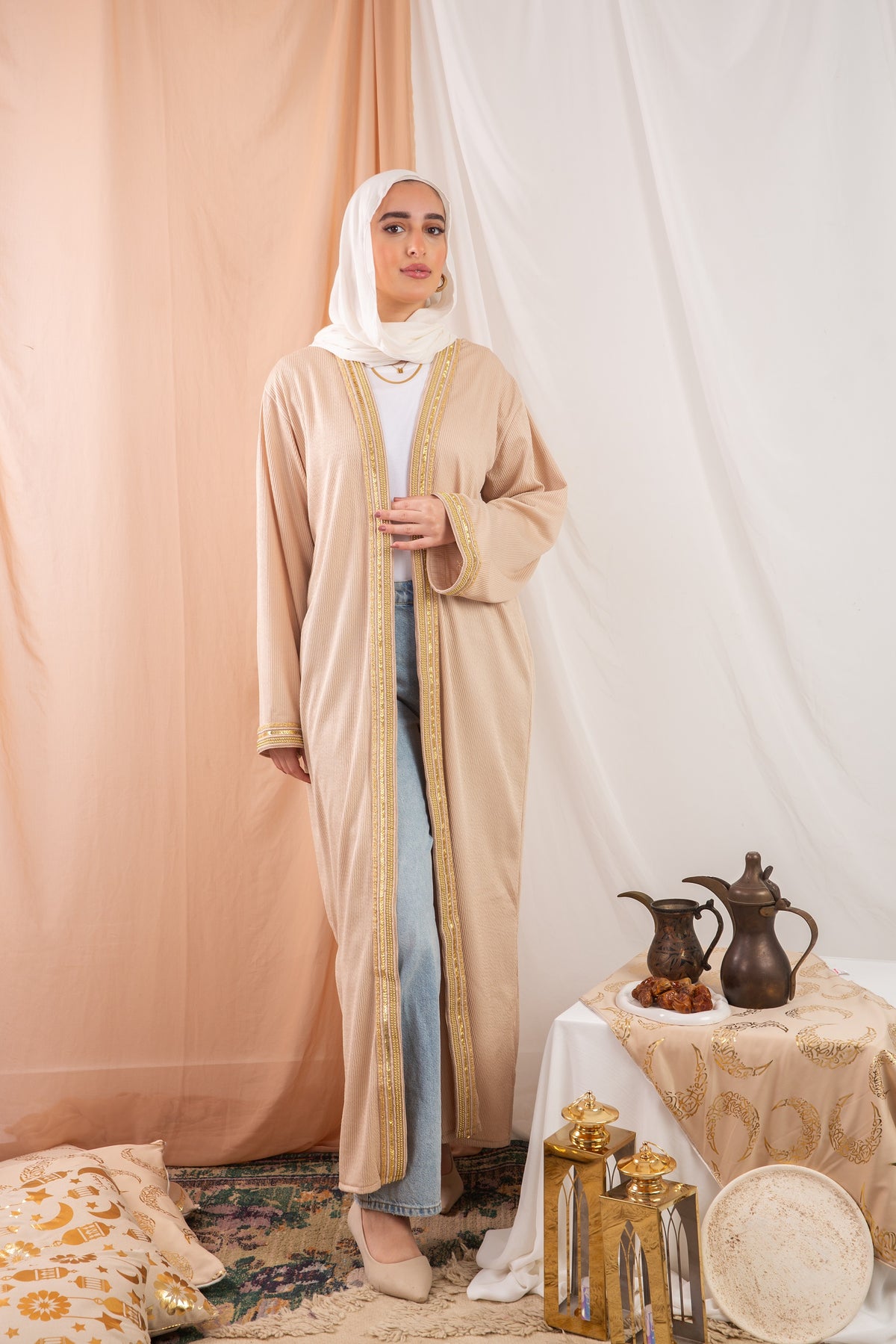Nojom Kaftan beige crafted from crinkle rib-knitted fabric, is adorned with delicate gold lines, adding a touch of elegance and sophistication.