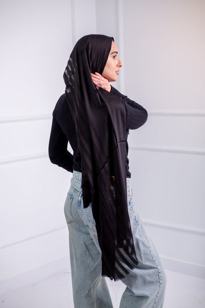 Silky black long hijab with line design, worn with casual jeans and a black top – back view 1