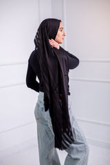 Silky black long hijab with line design, worn with casual jeans and a black top – back view 1