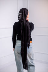 Silky black long hijab with line design, worn with casual jeans and a black top – back view2

