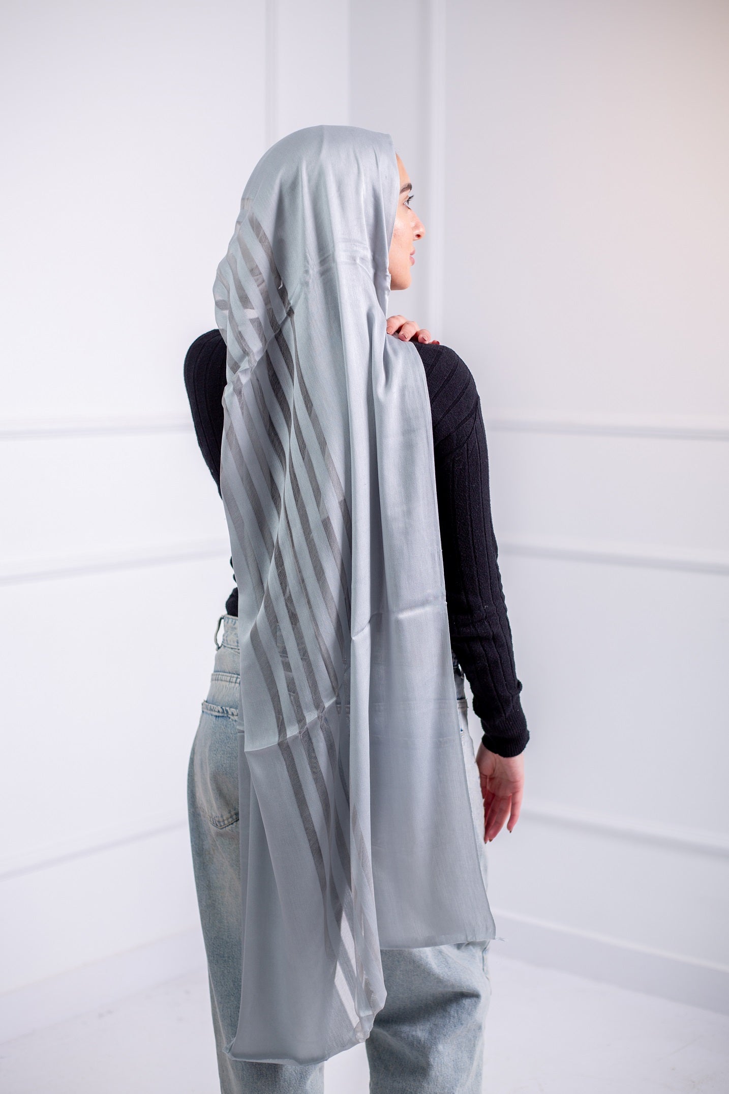 Silky Silver long hijab with line design, worn with casual jeans and a black top – back view2